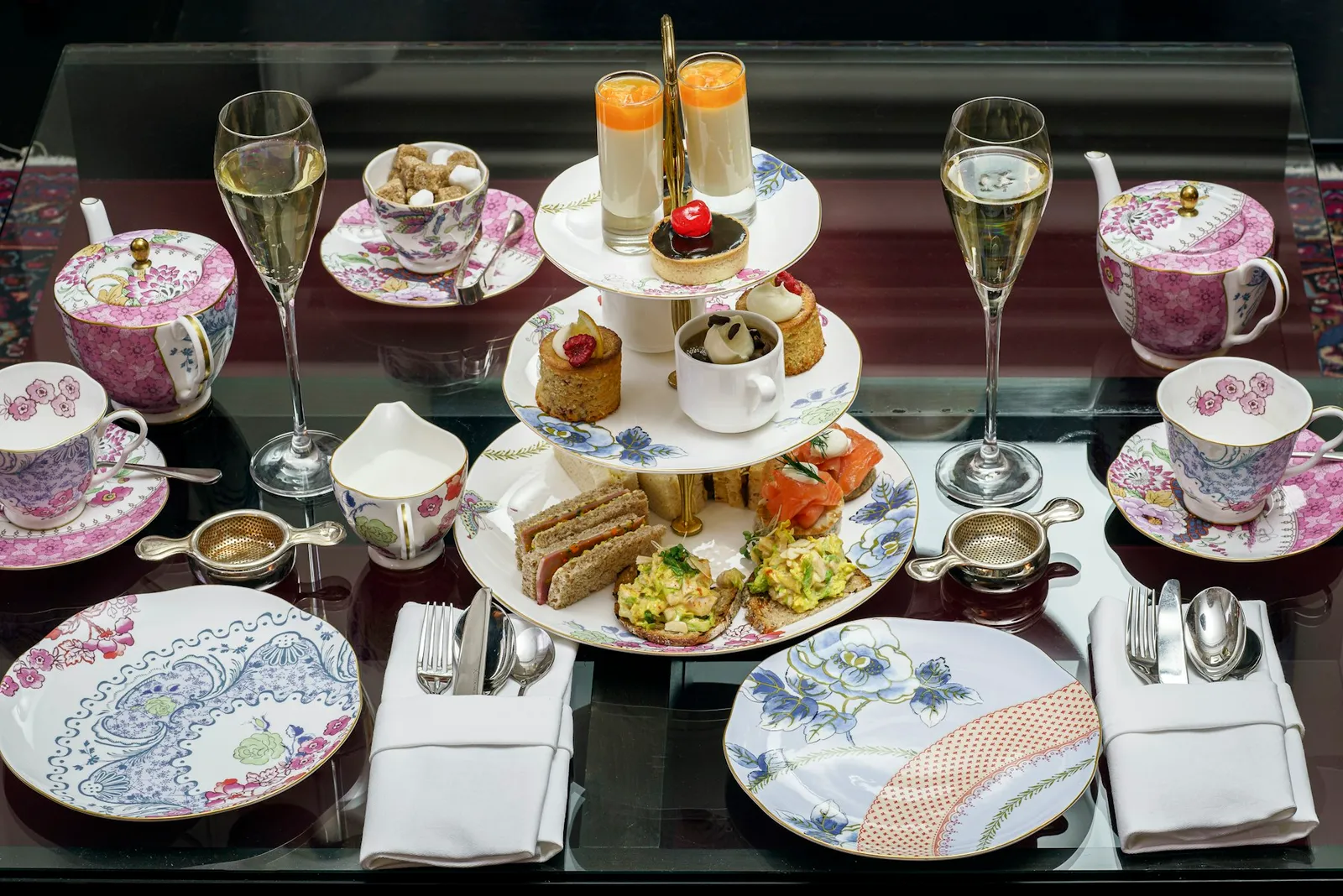 Merienda en vajilla de porcelana con torre de pastelería